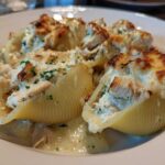 Four baked jumbo pasta shells filled with creamy chicken alfredo mixture and topped with melted, browned cheese.