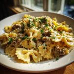 Close-up of creamy parmesan garlic beef bowtie pasta topped with fresh parsley and cheese.
