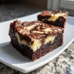 Close-up of a fudgy cream cheese brownies square showing the dark chocolate base and white cream cheese swirl.
