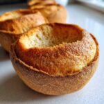 Close-up of a perfectly hollowed out, golden-brown bread bowl ready to be filled.