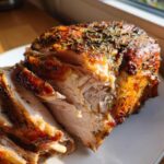 Close-up of juicy, sliced turkey breast coated in browned herb butter crust.