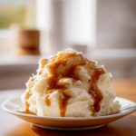 A mound of creamy mashed potatoes generously topped with rich, brown chicken gravy.