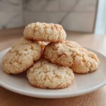 A stack of five freshly baked 3-ingredient butter cookies piled on a small white plate.
