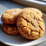 Close-up of three crinkled brown butter sugar cookies generously coated in sparkling sugar.