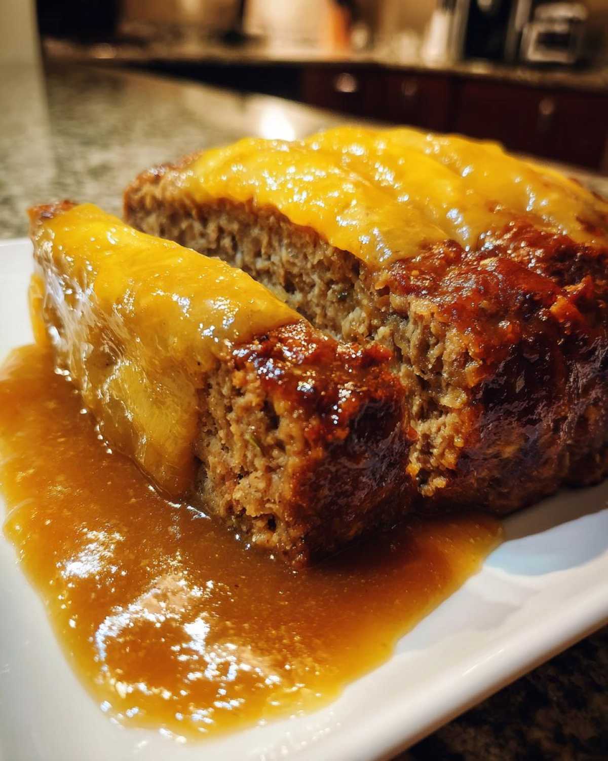 Close-up of sliced crockpot french onion meatloaf covered in a thick, savory onion glaze.