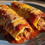 Two rolled cheese enchiladas smothered in red sauce and melted cheddar and Monterey Jack cheese.
