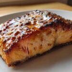 Close-up of a perfectly cooked salmon recipe fillet with a thick, shiny honey garlic glaze.