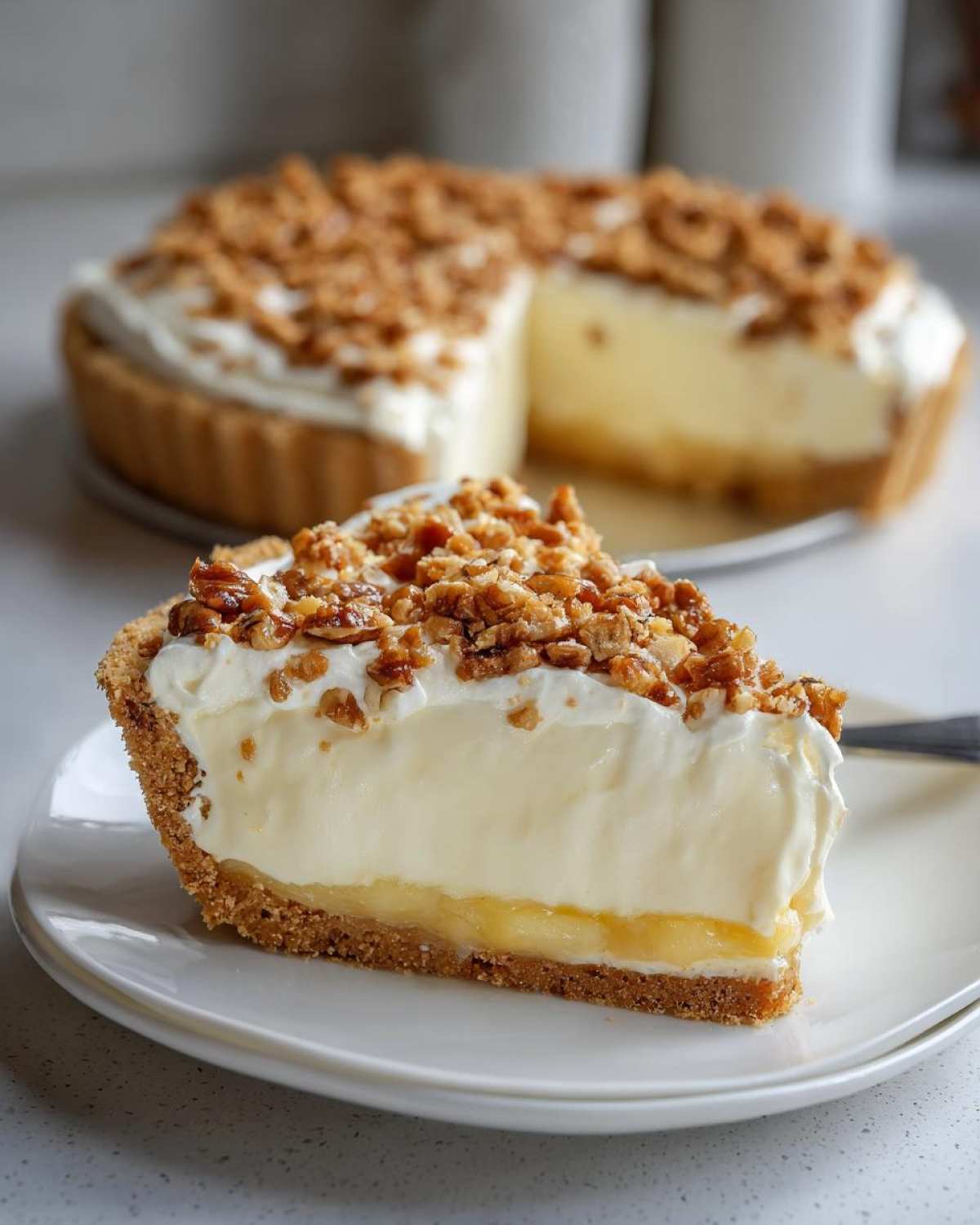 A close-up slice of million dollar pie showing graham cracker crust, creamy filling, and pecan topping.