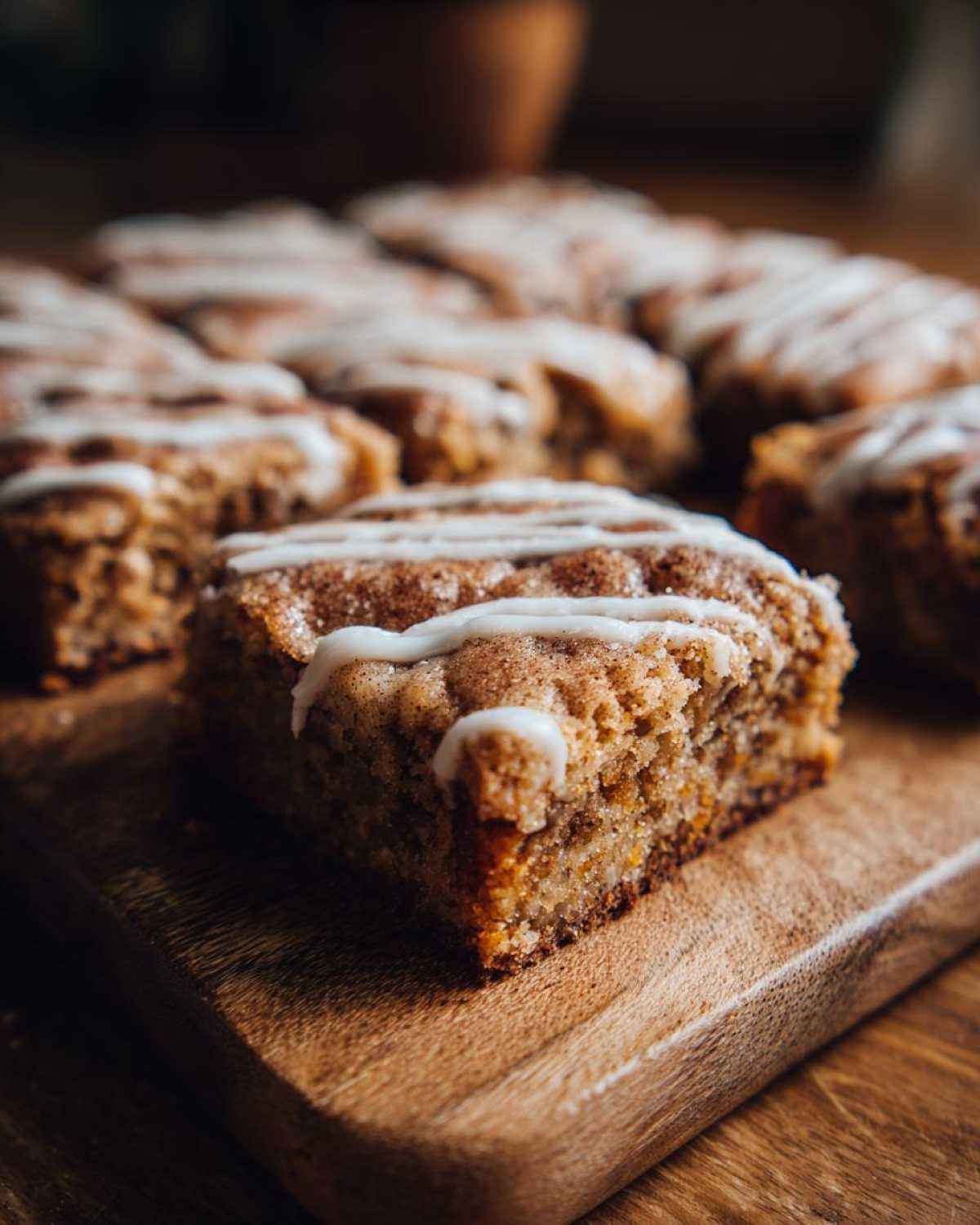 Close-up of a square snickerdoodle blondies slice with cinnamon sugar topping and white icing drizzle.