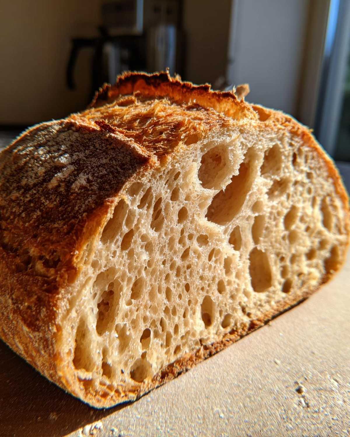 Close-up of a freshly baked sourdough bread slice showing an open, airy crumb structure, achieved using an active sourdough starter.