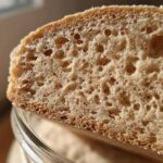 Macro shot showing the airy, bubbly interior crumb structure of bread made with a sourdough starter.