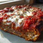 A thick, baked slice of chicken parmesan recipe, topped with melted mozzarella and rich tomato sauce.