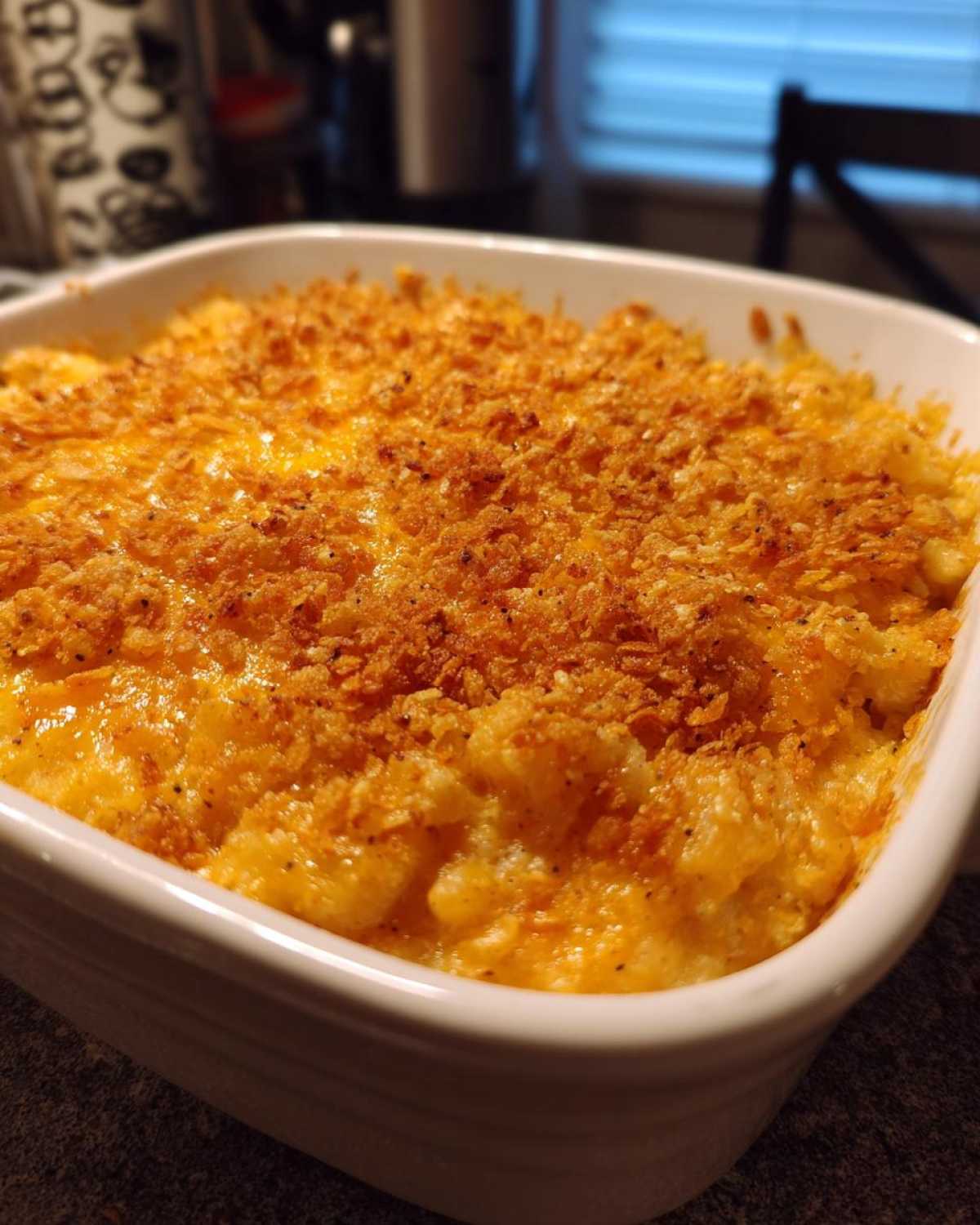 Close-up of a baked potato casserole bubbling with cheese and topped with a golden, crispy breadcrumb crust.