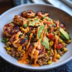 Close-up of a delicious shrimp bowl featuring grilled shrimp, brown rice, corn, avocado slices, and a spicy orange sauce.
