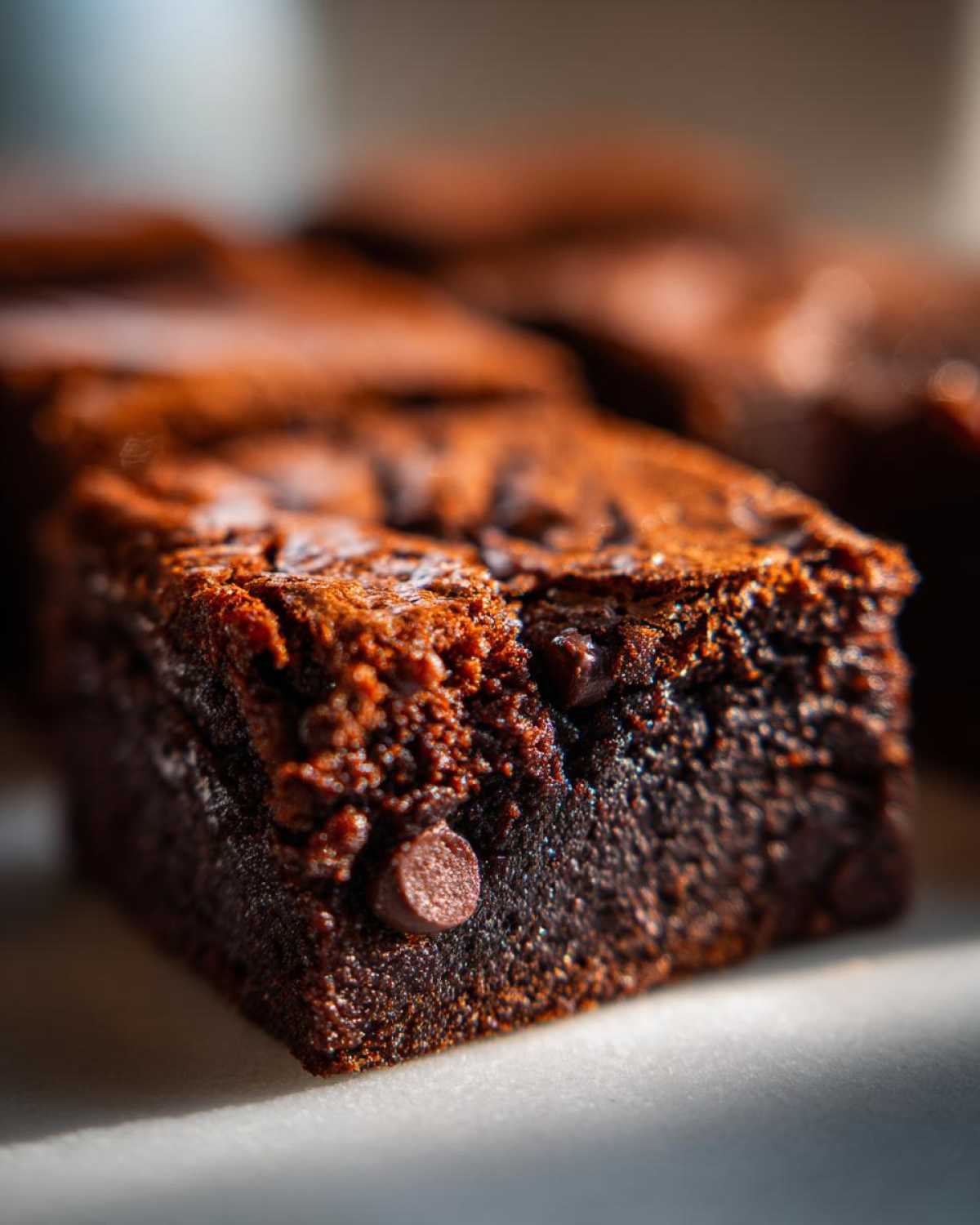 A close-up, macro shot showing the fudgy texture and visible chocolate chips in a slice of gingerbread brownies.