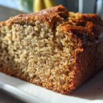 Close-up of a moist slice of freshly baked greek yogurt banana bread showing its rich brown crust.