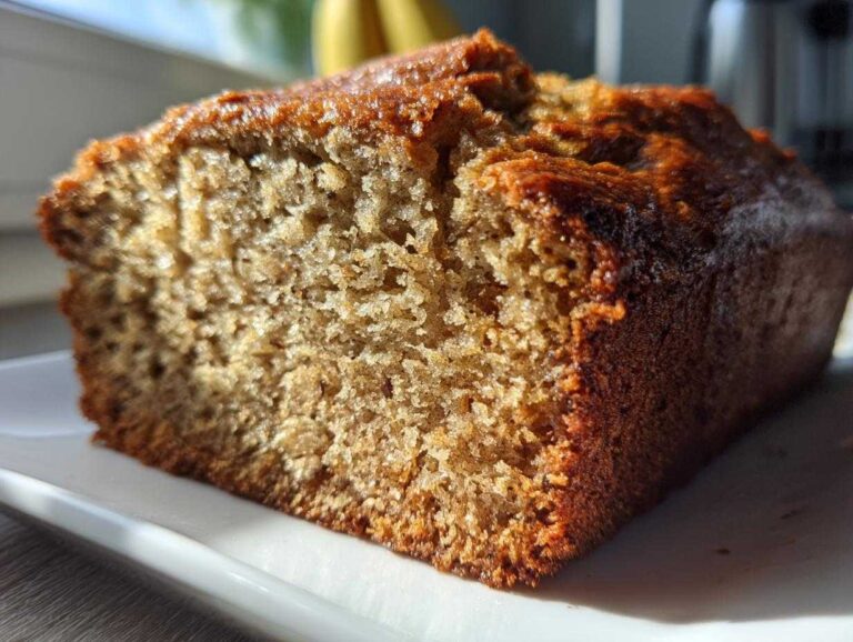 Close-up of a moist slice of freshly baked greek yogurt banana bread showing its rich brown crust.