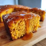 Close-up of a slice of moist sweet potato cornbread dripping with amber glaze.