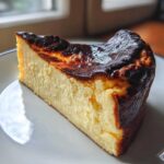 A rich, creamy slice of basque cheesecake showing its signature dark, caramelized top.