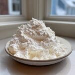 A mound of white, fluffy 2-Ingredient Fluffy Cloud Dough mixture piled high in a small ceramic bowl.