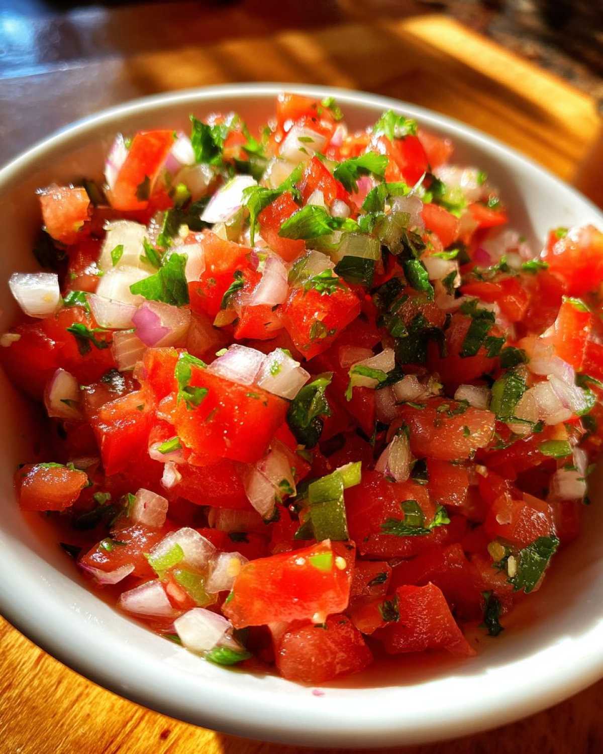 Close-up of fresh, chunky Authentic Pico de Gallo with diced tomatoes, red onion, and cilantro.