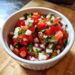 Close-up of fresh Authentic Pico de Gallo with Lime, featuring diced tomatoes, white onion, and cilantro in a white bowl.