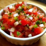 Close-up of fresh Authentic Pico de Gallo with Lime, featuring diced tomatoes, onions, and cilantro in a small white bowl.