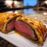 Cross-section of a perfectly cooked Beef Wellington Individual Servings showing medium-rare pink center and golden pastry.