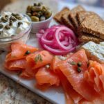Close-up of a Breakfast Grazing Board with Smoked Salmon, cream cheese, pickled onions, and crackers.