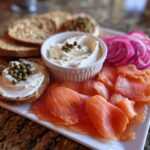 Close-up of a Breakfast Grazing Board with Smoked Salmon, cream cheese, capers, and pickled red onions.