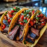Close-up of three delicious Carne Asada Tacos filled with grilled steak and topped with fresh pico de gallo salsa.