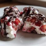 Four homemade Chocolate Strawberry Yogurt Clusters drizzled with melted chocolate on a white plate.