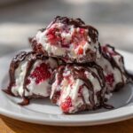 A stack of delicious Chocolate Strawberry Yogurt Clusters drizzled with melted chocolate on a white plate.