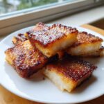A stack of golden brown, pan-fried Crispy Shanghai Butter Mochi squares with a shiny, caramelized exterior.