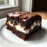 A single, rich square of Deviled Brownies with Marshmallow Filling showing the thick, gooey white center.