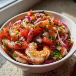 Close-up of vibrant Fresh Shrimp Ceviche with Citrus, mixed with diced tomatoes, red onion, and cilantro.