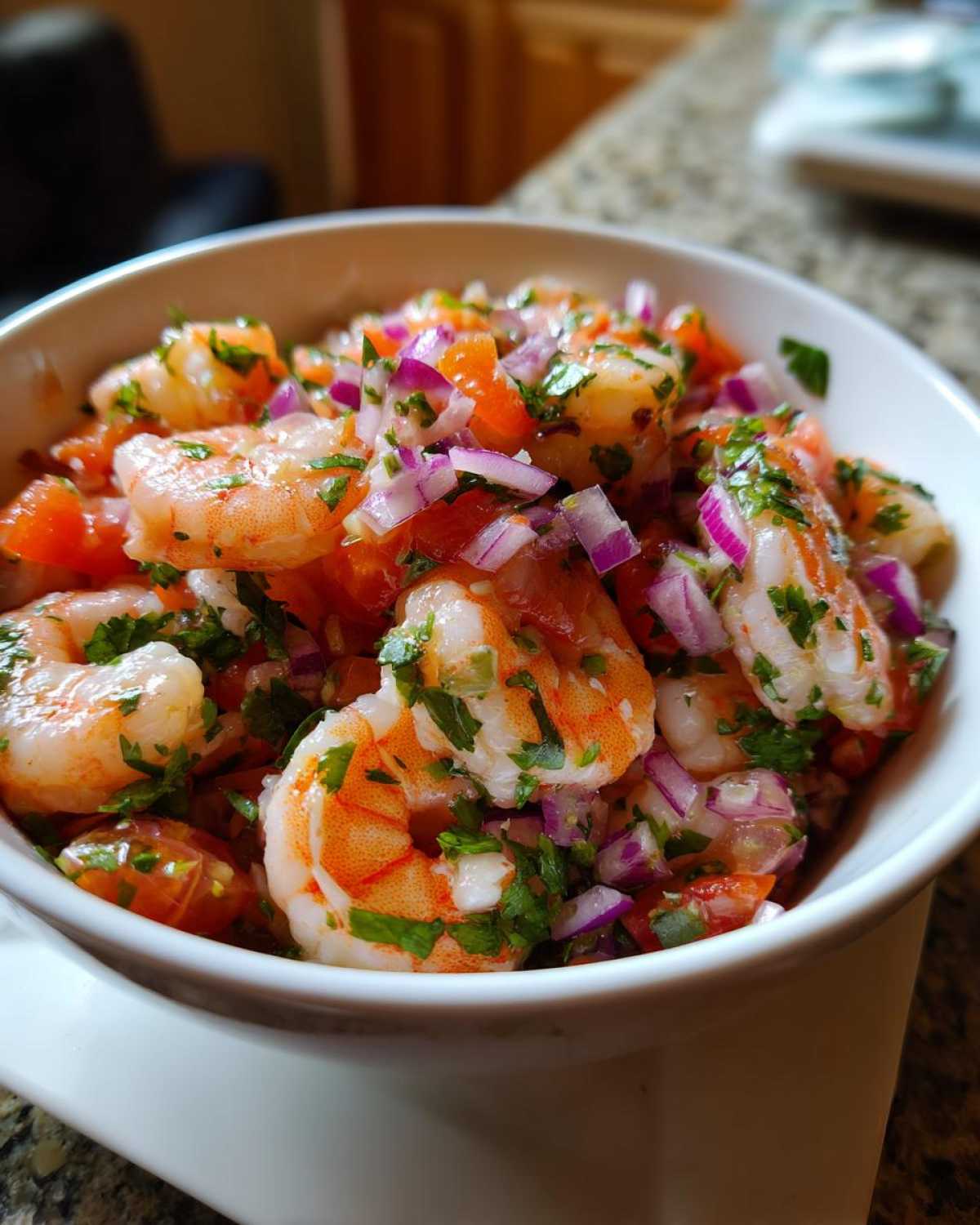 Close-up of vibrant Fresh Shrimp Ceviche with Citrus, featuring plump shrimp, diced red onion, and cilantro in a white bowl.