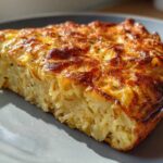 A thick slice of Leftover Spaghetti Frittata showing cooked pasta bound in egg with a deeply browned, cheesy top.