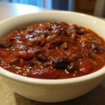 Close-up of a rich, thick serving of Pantry Staple Chili with Beans in a white bowl.