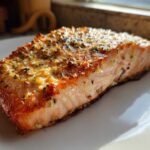 Close-up of a perfectly cooked fillet of Ridiculously Good Air Fryer Salmon with a golden, herbed crust.