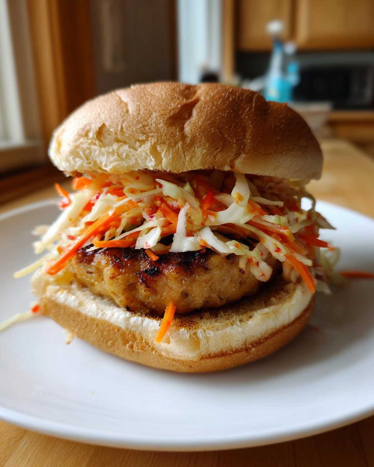 A close-up of a Roasted Cabbage Burger topped generously with spicy slaw, served on a toasted bun.