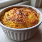 Close-up of golden-brown Single-Serving Carrot Cake Baked Oats baked in a white fluted ramekin.