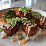 Close-up of Teriyaki Tofu Bowls featuring glazed tofu cubes over rice, topped with Kimchi Mayo, sesame seeds, and green onions.