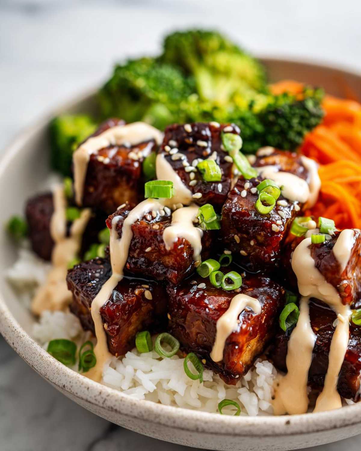 Close-up of Teriyaki Tofu Bowls featuring glazed tofu cubes over rice, topped with Kimchi Mayo and green onions.