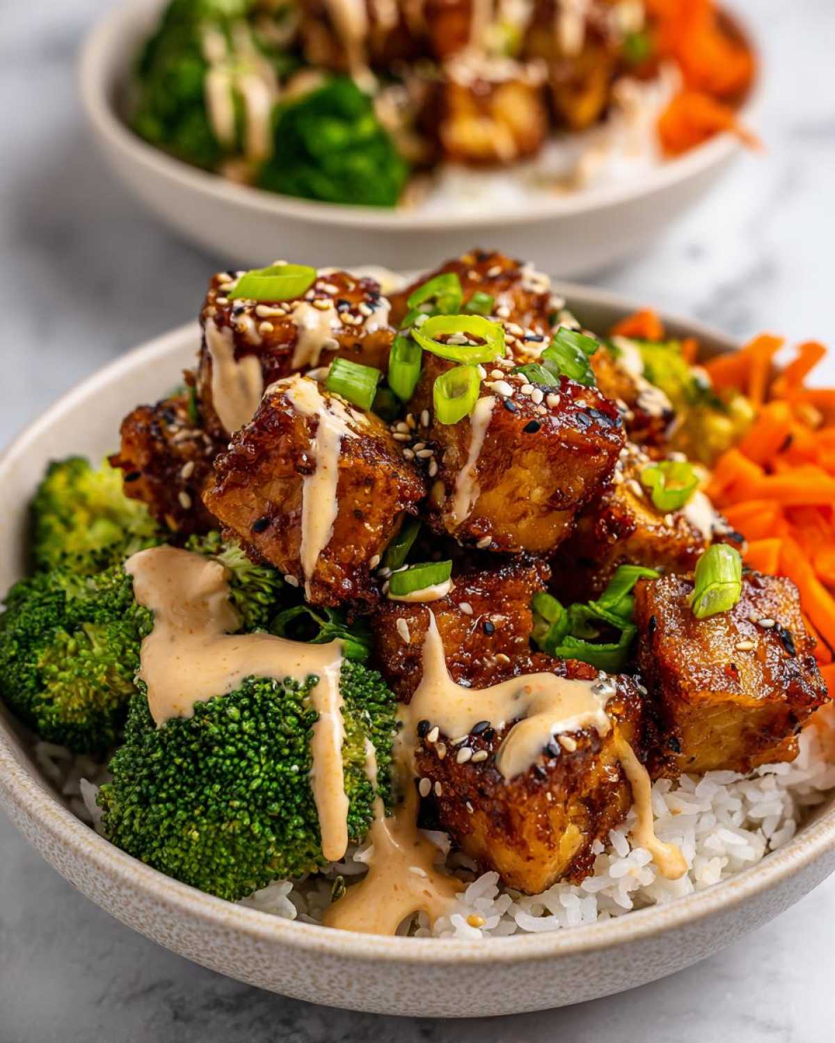 Close-up of a Teriyaki Tofu Bowls with Kimchi Mayo, featuring glazed tofu cubes over rice with broccoli and carrots.