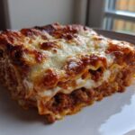 A perfectly baked slice of Viral No-Fold Dumpling Lasagna showing layers of meat sauce and melted cheese.