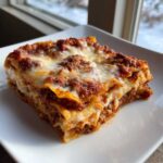 A thick, cheesy slice of Viral No-Fold Dumpling Lasagna served on a white square plate.